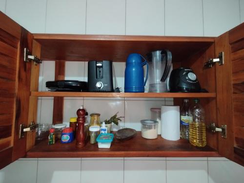 a kitchen shelf with various items on it at Suíte Privativa in Paraty