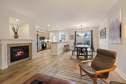 a living room with a fireplace and a table with chairs at Tranquility on the Bluffs in Bend