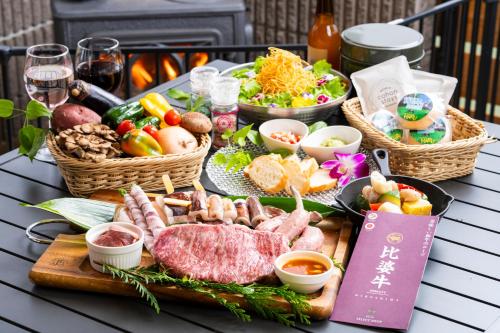 a table topped with a buffet of meats and vegetables at 備北丘陵公園　湖畔ステイズ庄原 in Shōbara