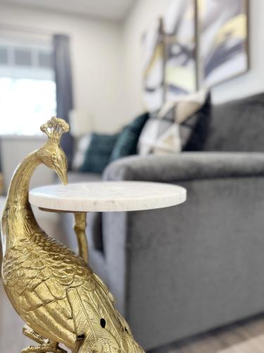 a statue of a rooster sitting on a table in a living room at RiverStone Retreat - Newburgh IN Stylish Apartments in Newburgh