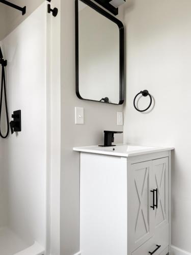 a bathroom with a mirror and a white cabinet at RiverStone Retreat - Newburgh IN Stylish Apartments in Newburgh