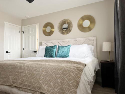 a bedroom with a bed with two mirrors on the wall at RiverStone Retreat - Newburgh IN Stylish Apartments in Newburgh