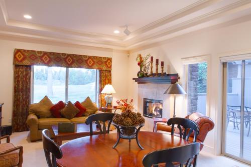 a living room with a table and a fireplace at Villa #5 at Broken Top in Bend