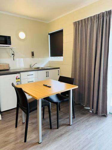 a kitchen with a table and chairs in a room at Colonial City Motel in Hamilton
