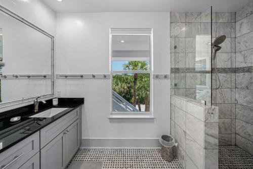 baño con ducha, lavabo y ventana en Come Together-consist of 2 Homes 4 Golf Carts 2 pools, en Captiva