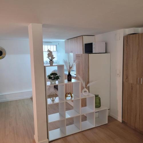 - une étagère blanche dans le salon dans l'établissement Charming Garden Floor studio, à Gagny