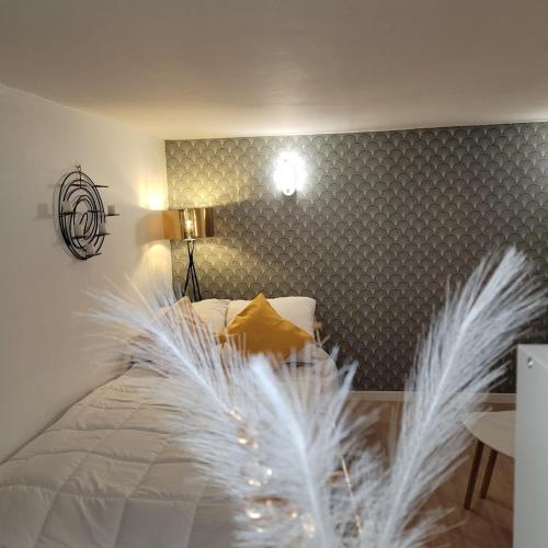 - une chambre dotée d'un lit avec des plumes blanches dans l'établissement Charming Garden Floor studio, à Gagny