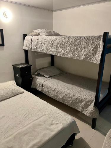 a bedroom with two bunk beds and a night stand at Apartamentos en el rodadero in Rodadero