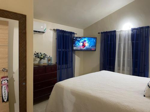 ein Schlafzimmer mit einem Bett und einem Flachbildfernseher in der Unterkunft Symone Palms Retreat in Montego Bay