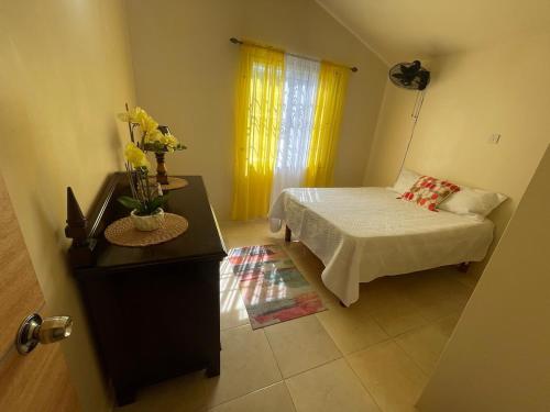 ein Schlafzimmer mit einem Bett, einer Kommode und einem Tisch in der Unterkunft Symone Palms Retreat in Montego Bay