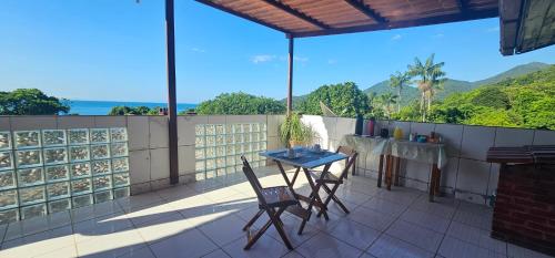 a table and chairs on a balcony with a view of the ocean at Pousada Encontro das Águas in Trindade