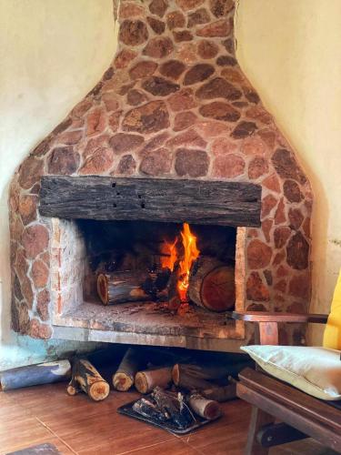a brick fireplace with a fire in it at Chacra Mahatma in Tacuarembó