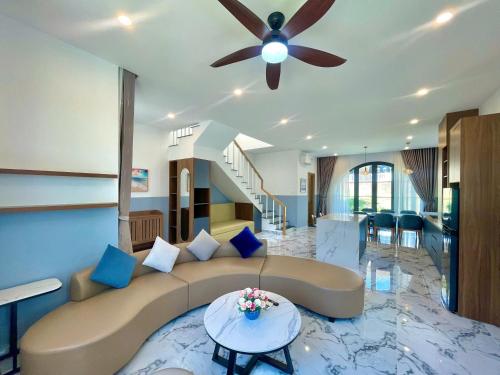 a living room with a couch and a ceiling fan at Villa Novaworld Phan Thiết in Bình Tú