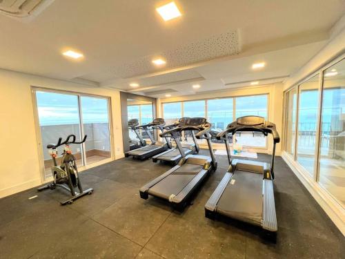 a row of treadmills in a gym with windows at Apto moderno c/ Vista Incrível para o Mar in Itaparica
