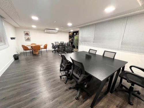 an office with a desk and chairs and a table at Apto moderno c/ Vista Incrível para o Mar in Itaparica