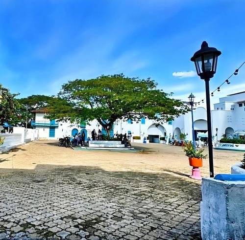 a street light and a tree in a courtyard at Hotel Santorini Aldea Doradal in Puerto Triunfo
