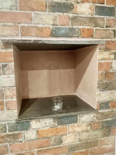 a cup sitting in a box on a brick wall at Casinha das Estrelas in Cerejeira