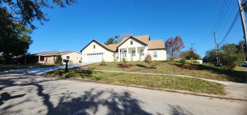 a white house on the side of a street at Orlando Home Vacation near Universal Studios - 3 BR in Orlando