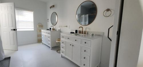 a white bathroom with two sinks and a mirror at Orlando Home Vacation near Universal Studios - 3 BR in Orlando