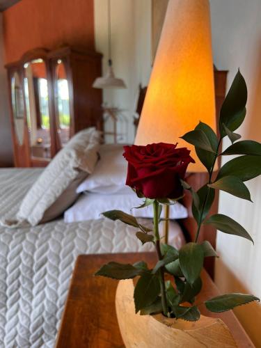 a red rose on a table next to a lamp at Pousada Borghetto – Charme e Exclusividade no Vale dos Vinhedos in Bento Gonçalves