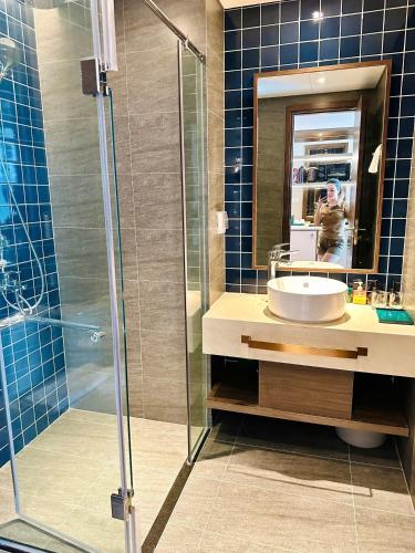 a bathroom with a sink and a glass shower at Khách Sạn Apec Mũi Né Phan Thiết in Ấp Thiẹn Ái