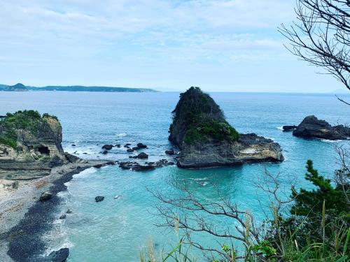 a beach with some rocks in the water at HealingDragon Ryugu cottage in Shimoda