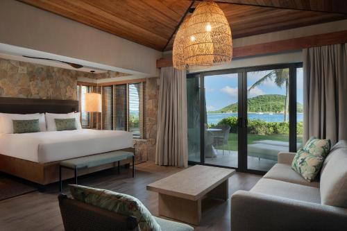 ein Schlafzimmer mit Bett und ein Wohnzimmer in der Unterkunft Peter Island Resort in Anderson