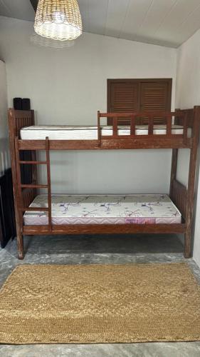 a pair of bunk beds in a room with a rug at Vila PanaPaná in Maxaranguape