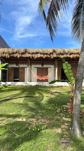 a house with a hammock in front of it at Vila PanaPaná in Maxaranguape