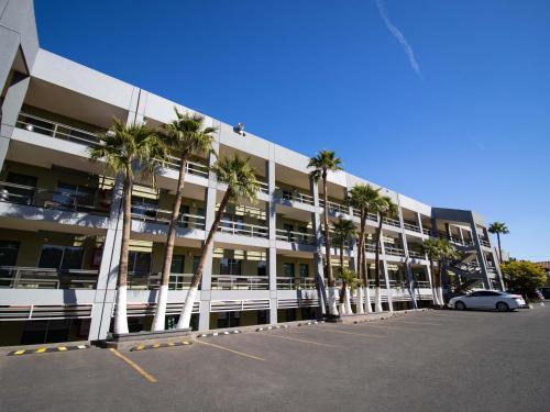 a parking lot with palm trees in front of a building at Hotel Calafia in Mexicali