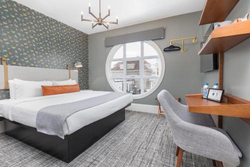 a bedroom with a bed and a desk and a window at Prentiss House by Thatch in Cambridge