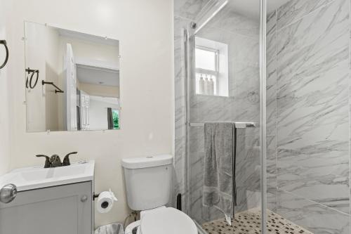 a bathroom with a shower and a toilet and a sink at 3 bedrooms and 2 bathrooms Charming Beachside House with King Bed in Pompano Beach