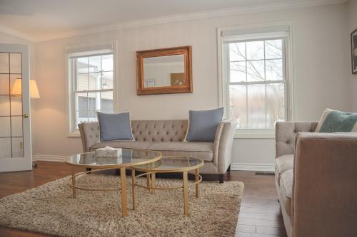 een woonkamer met een bank en een tafel bij The Promenade Cottage License # 002-2023 in Niagara on the Lake