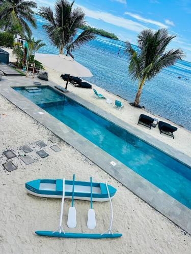 a blue surfboard on the beach next to a swimming pool at Pension Irivai, appartement UO UO 3 chambres vue mer in Uturoa