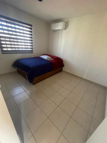 una piccola camera da letto con un letto e una finestra di Departamento Mazatlan a Mazatlán