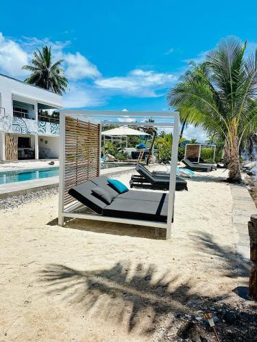 a bed on the beach next to a swimming pool at Pension Irivai appartement PUATOU 1 chambre bord de mer in Uturoa
