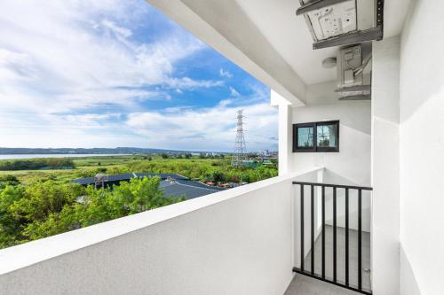 a balcony with a view of a field at 25Inn Hengchun Kenting in Nanwan