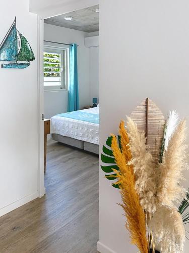 a bedroom with a bed and a room with a mirror at Pension Irivai appartement PUATOU 1 chambre bord de mer in Uturoa