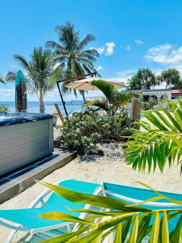 a beach with chairs and umbrellas on the sand at Pension Irivai, Appartement RAVA 1 chambre bord de mer in Uturoa