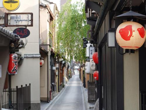 a narrow street with signs on the side of buildings at Kansei 京都八条 in Kyoto