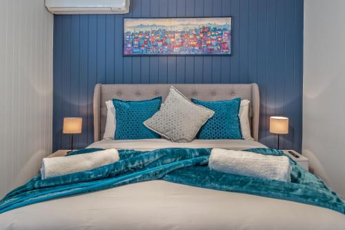 a bedroom with a large bed with blue walls at The Mooloolaba Gallery in Mooloolaba
