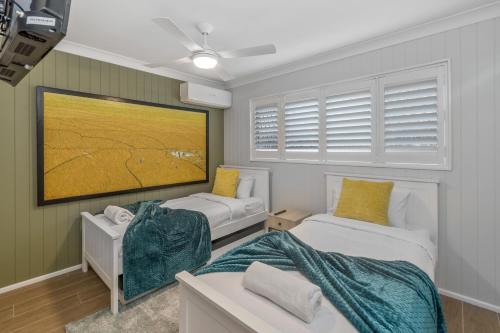 a room with two beds and a flat screen tv at The Mooloolaba Gallery in Mooloolaba