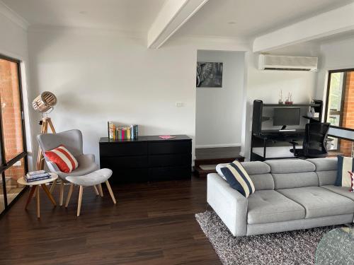 a living room with a couch and a tv at Waterfront Paradise with Jetty, BBQ, Pool table, & more in Dora Creek