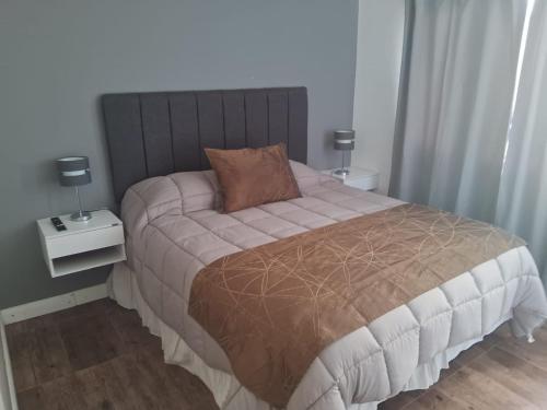 a bedroom with a large bed with two night stands at Altos Patagonia in Río Gallegos
