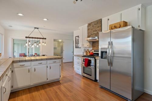 a kitchen with white cabinets and a stainless steel refrigerator at Boots and Barrels Ranch in Paso Robles