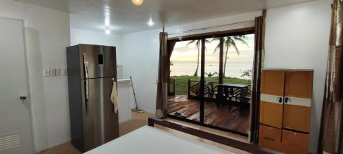 a kitchen with a sliding glass door with a view of the ocean at John and Novy Camotes Beach Bungalows in San Francisco