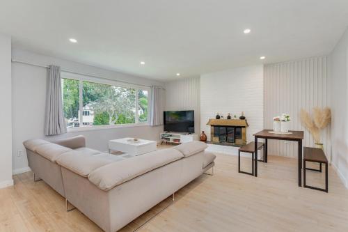 a white living room with a couch and a tv at Stunning House In Victoria, BC in Victoria