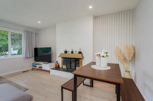 a living room with a table and a tv at Stunning House In Victoria, BC in Victoria