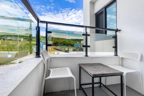 a balcony with a table and two chairs and a window at 25Inn Hengchun Kenting in Nanwan