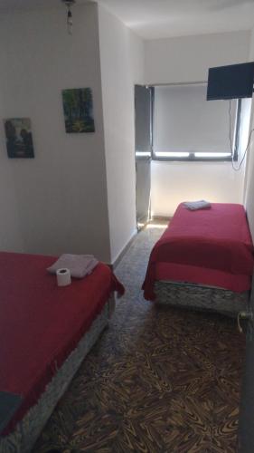 a room with two beds and a window in it at Parque Chacabuco in Mar del Plata
